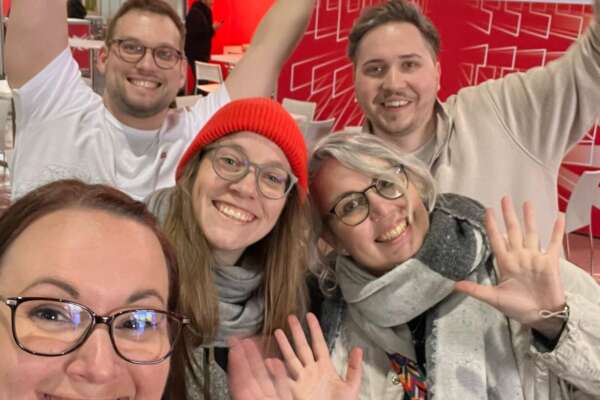 Jubelnde Personen, die den Messeaufbau erledigt haben.